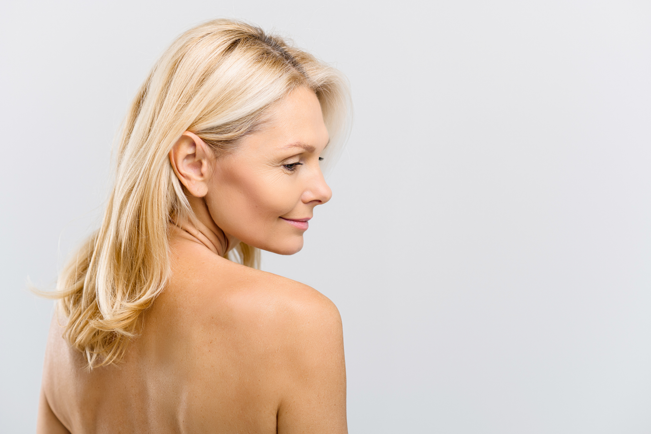 Woman looking over her shoulder after acne treatment in Hobart